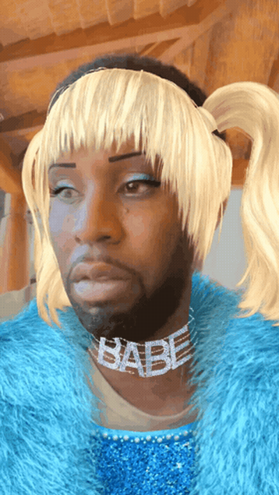 A Man Wearing A Blue Fur Coat And A Babe Necklace GIF