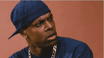 A Man Wearing A Blue Hat And A Gold Chain Is Smoking A Cigarette GIF