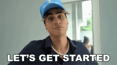 A Man Wearing A Blue Hat And A Pearl Necklace Says " Let 'S Get Started " GIF