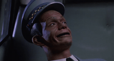 A Man Wearing A Blue Hat And A Suit Is Being Hit By A Bullet GIF
