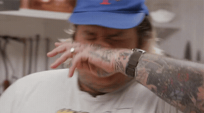A Man Wearing A Blue Hat And A White Shirt Has A Tattoo On His Arm GIF