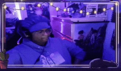 A Man Wearing A Blue Hat And Glasses Is Sitting In Front Of A Computer Screen . GIF