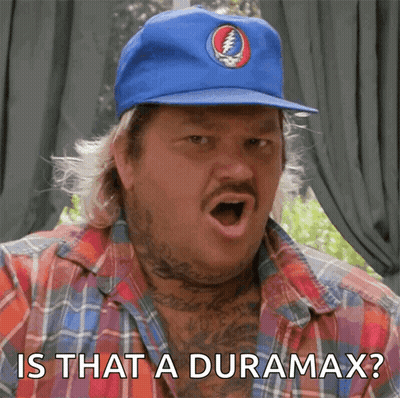 a man wearing a blue hat with a grateful dead logo on it says " is that a duramax "