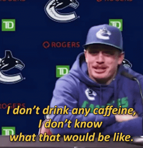 A Man Wearing A Blue Hoodie And A Blue Hat Is Talking Into A Microphone GIF