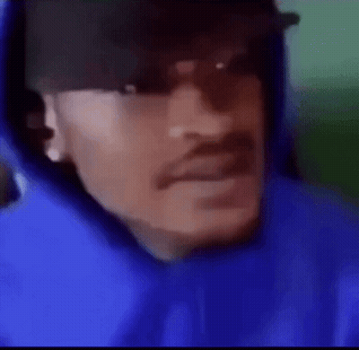A Man Wearing A Blue Hoodie And A Hat . GIF