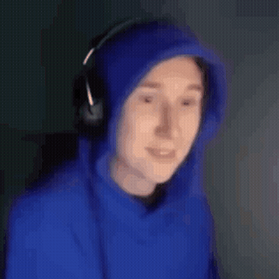 a man wearing a blue hoodie and headphones is smiling and looking at the camera .