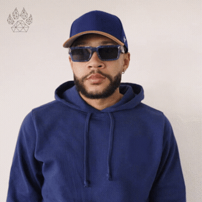 A Man Wearing A Blue Hoodie And Sunglasses Stands In Front Of A Paw Print GIF