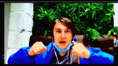 A Man Wearing A Blue Jacket And A Mask Is Making A Funny Face While Talking On A Video Call . GIF