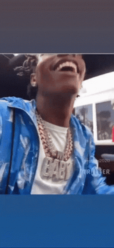 A Man Wearing A Blue Jacket And A Necklace With The Word Baby On It . GIF