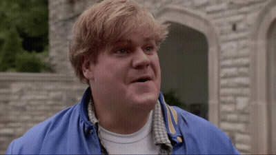 A Man Wearing A Blue Jacket And A White Shirt Is Standing In Front Of A Stone Wall GIF