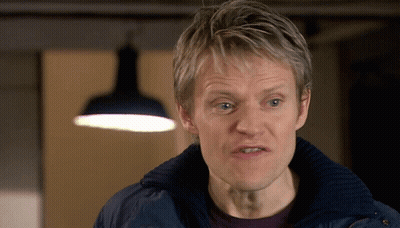 A Man Wearing A Blue Jacket Looks At The Camera GIF