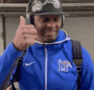 A Man Wearing A Blue Jacket With The Letter M On It Gives A Thumbs Up GIF