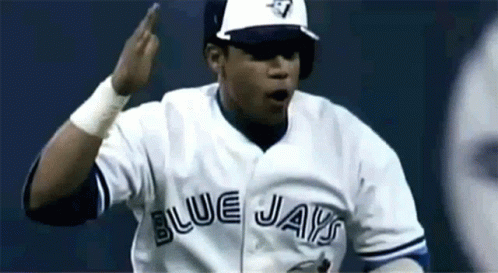A Man Wearing A Blue Jays Jersey Is Making A Gesture GIF