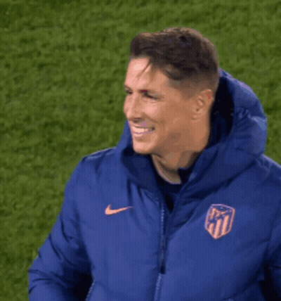 A Man Wearing A Blue Nike Jacket With A Crest On It GIF