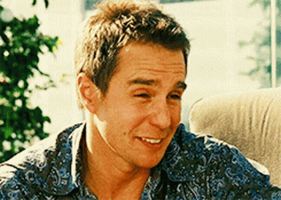 A Man Wearing A Blue Paisley Shirt Is Smiling GIF