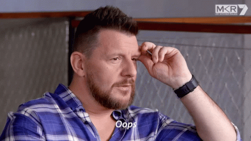 A Man Wearing A Blue Plaid Shirt And A Black Watch Says Oops GIF