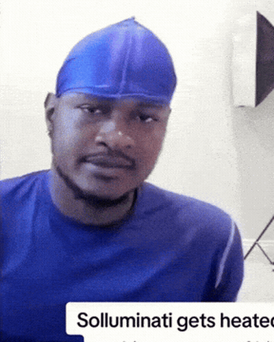 A Man Wearing A Blue Shirt And A Blue Hat With The Words Solluminati Gets Heated On The Bottom GIF