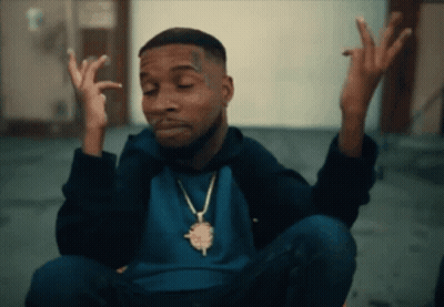 A Man Wearing A Blue Shirt And A Gold Necklace Is Making A Face GIF