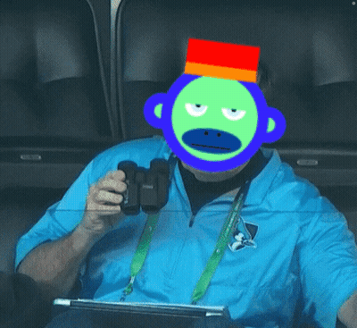 A Man Wearing A Blue Shirt And A Green Monkey Mask GIF