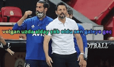 A Man Wearing A Blue Shirt And A White Shirt Is Standing Next To Another Man . GIF