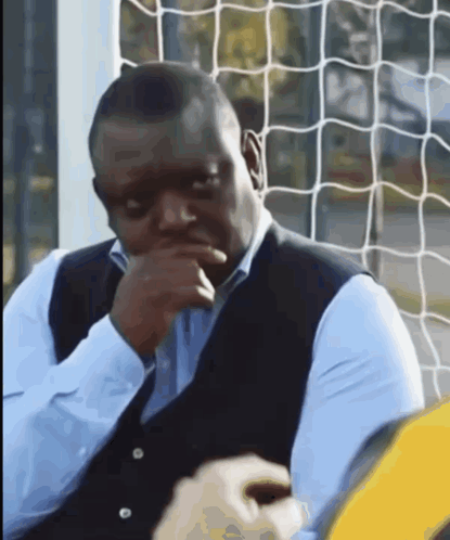 Man In Blue Shirt Sitting In Front Of Soccer Net GIF
