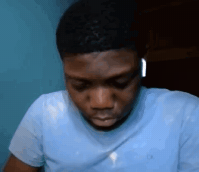 A Man Wearing A Blue Shirt And Ear Buds GIF