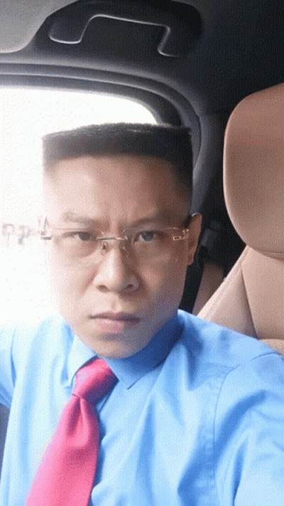A Man Wearing A Blue Shirt And Red Tie Is Sitting In The Driver 'S Seat Of A Car GIF