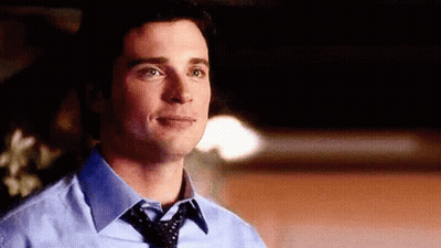 A Man Wearing A Blue Shirt And Tie Is Looking At The Camera . GIF
