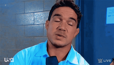 A Man Wearing A Blue Shirt And Tie Is Talking Into A Microphone While Watching W Live GIF