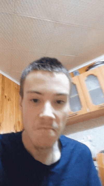 A Man Wearing A Blue Shirt Is Making A Funny Face GIF