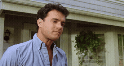 A Man Wearing A Blue Shirt Is Standing In Front Of A House GIF
