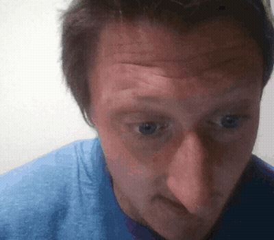 A Man Wearing A Blue Shirt Looks At The Camera GIF