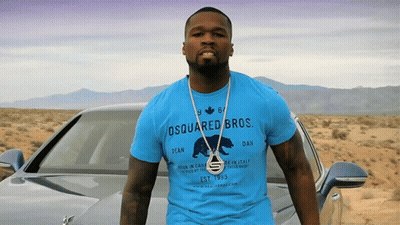 A Man Wearing A Blue Shirt That Says Dsquared Bros Stands In Front Of A Car GIF