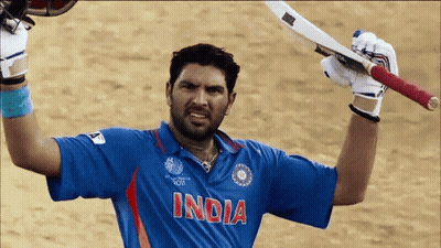 A Man Wearing A Blue Shirt That Says India Holds Up His Bat GIF