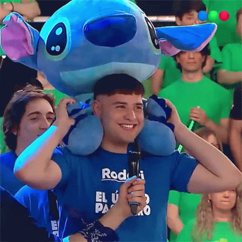 A Man Wearing A Blue Shirt That Says Rod Holds A Microphone GIF