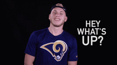A Man Wearing A Blue Shirt With A Ram On It Is Smiling And Says Hey What 'S Up GIF