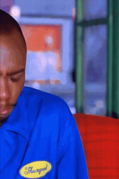 A Man Wearing A Blue Shirt With A Yellow Badge That Says Heavygod On It GIF
