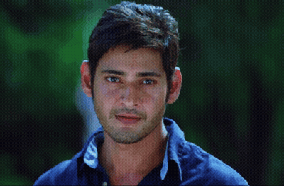 A Man Wearing A Blue Shirt With The Letter C On The Collar Smiles GIF