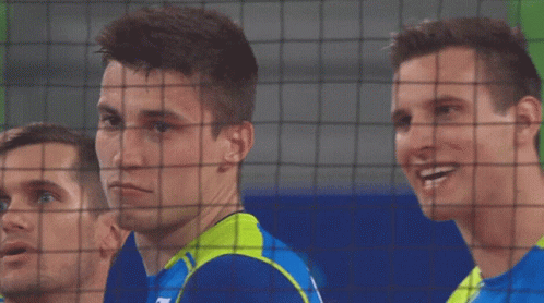 A Man Wearing A Blue Shirt With The Letter N On It Looks Behind A Net GIF