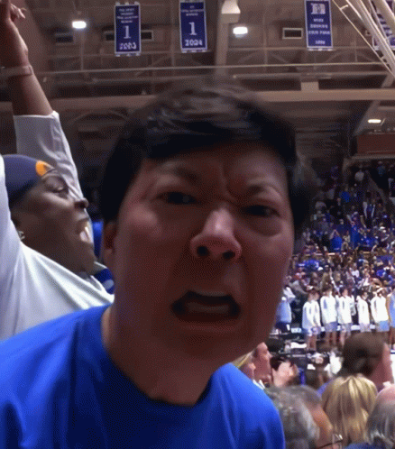 A Man Wearing A Blue Shirt With The Number 1 On It Stands In Front Of A Crowd GIF