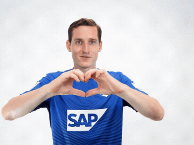 A Man Wearing A Blue Shirt With The Word Sap On It Makes A Heart Shape With His Hands GIF