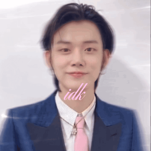 A Man Wearing A Blue Suit And A Pink Tie Has The Word Idk Above His Mouth GIF