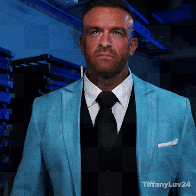 A Man Wearing A Blue Suit And Black Tie With Tiffanyluv24 In The Corner GIF