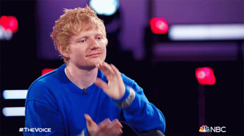 A Man Wearing A Blue Sweater With The Word The Voice On It GIF