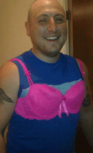 A Man Wearing A Blue Tank Top And Pink Bra GIF