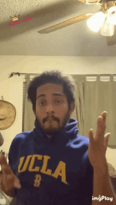 A Man Wearing A Blue Ucla Sweatshirt Makes A Funny Face GIF