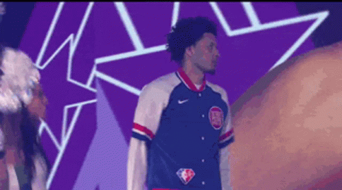 A Man Wearing A Blue White And Red Jacket With The Nba Logo On The Front GIF