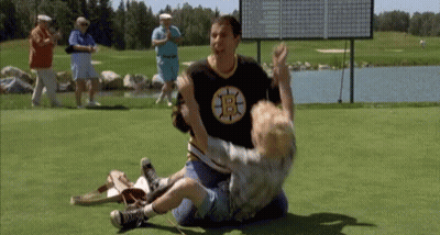 A Man Wearing A Boston Bruins Shirt Is Wrestling A Young Boy On A Golf Course . GIF