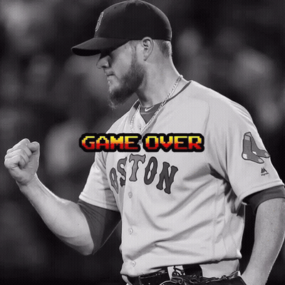 A Man Wearing A Boston Jersey Holds His Fist Up In Celebration GIF
