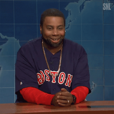 A Man Wearing A Boston Jersey Is Sitting At A Desk GIF